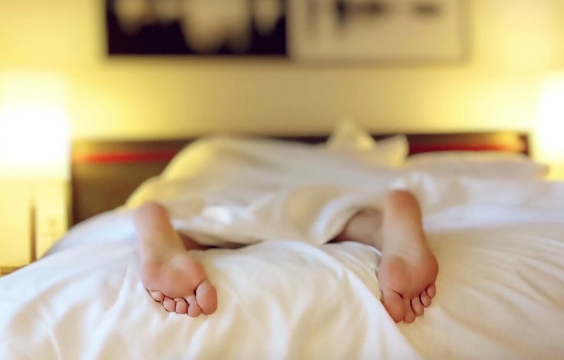 En persons fötter som sover i en säng. En persons fötter som sover i en säng.